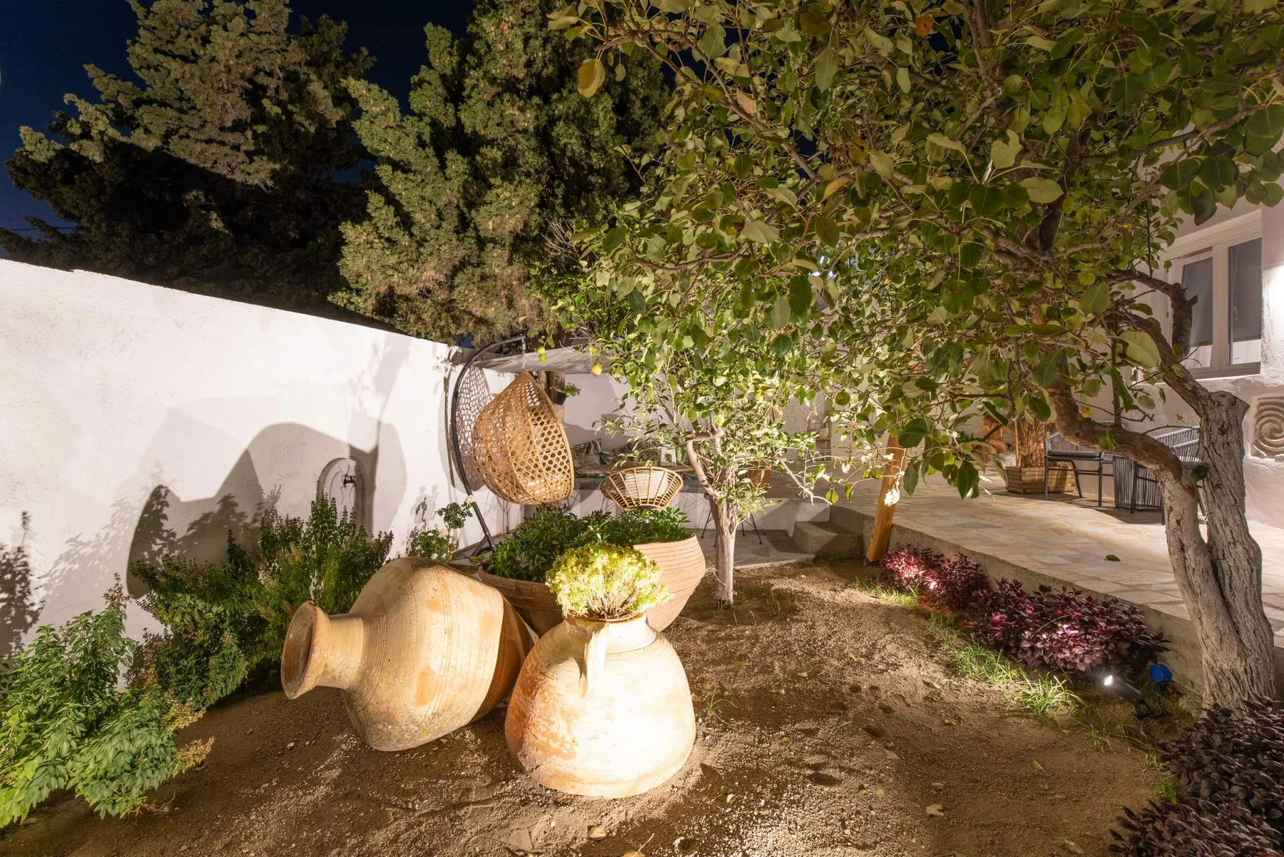 Garden with terracotta pots under the trees at night